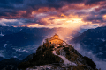 Stone mountain sanctuary on a ridge beneath sunset clouds